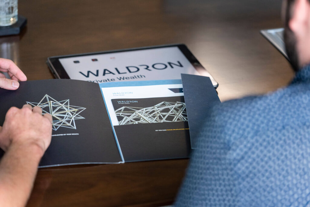 people reviewing Waldron printed material